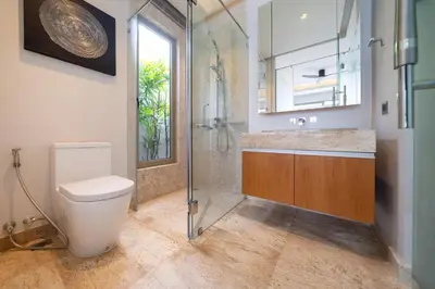 a bathroom with a toilet and a glass shower at Luxury 4BR Pool Villa Botanica Bangtao Beach in Ban Thalat Choeng Thale