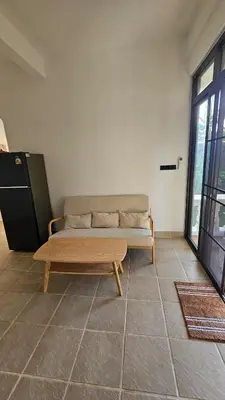 a couch sitting in a room with a large window at Tropical 1BR Bungalow in Rawai with Shared Pool in Nai Harn Beach
