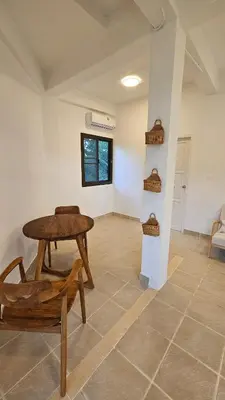 a room with a wooden table and a chair at Tropical 1BR Bungalow in Rawai with Shared Pool in Nai Harn Beach