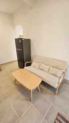 a couch and a coffee table in a room at Tropical 1BR Bungalow in Rawai with Shared Pool in Nai Harn Beach
