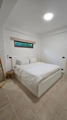 a bedroom with a large white bed with a window at Tropical 1BR Bungalow in Rawai with Shared Pool in Nai Harn Beach