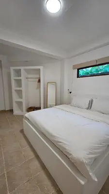 a white bedroom with a large bed and a window at Tropical 1BR Bungalow in Rawai with Shared Pool in Nai Harn Beach