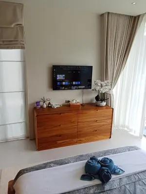 a living room with a television on a wooden dresser at Luxury Design 3 Bedroom Villa AB2 in Phuket Town