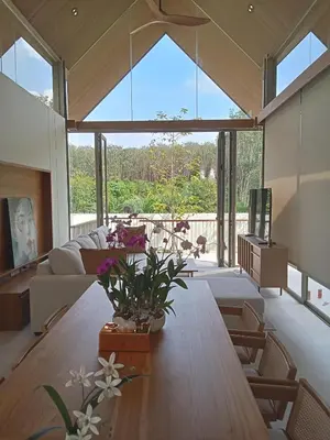 a living room with a wooden table with flowers on it at Luxury Design 3 Bedroom Villa AB2 in Phuket Town