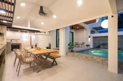a dining room with a table and a swimming pool at At Bangla Patong Pool Moon villa in Patong Beach