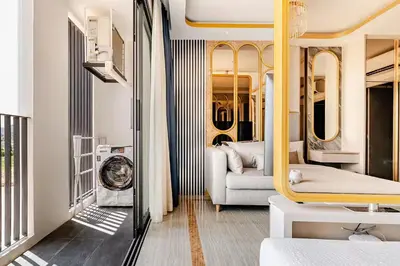 a train room with a couch and a chair at Bellevue by Villacarte in Laguna Phuket