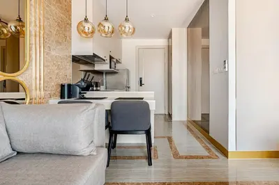 a living room with a couch and a kitchen at Bellevue by Villacarte in Laguna Phuket