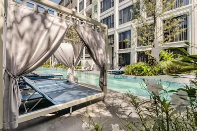 a bed in front of a pool in a building at Bellevue by Villacarte in Laguna Phuket