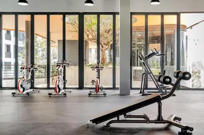 a gym with several exercise bikes in front of a building at Bellevue by Villacarte in Laguna Phuket