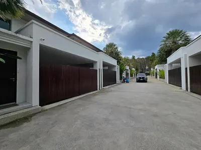 a car parked on a street next to a building at Bangtao Family 3 Bedroom Villa in Ban Pak Lak