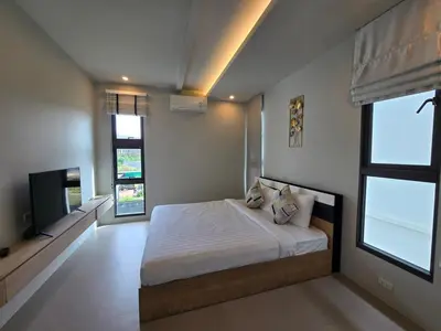 a bedroom with a bed and a flat screen tv at Bangtao Family 3 Bedroom Villa in Ban Pak Lak