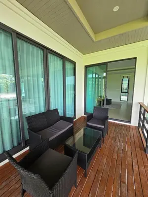 a screened in porch with couches and a coffee table at Bangtao Family 3 Bedroom Villa in Ban Pak Lak