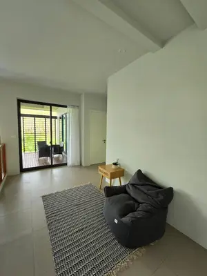 a living room with a black couch on a rug at Bangtao Family 3 Bedroom Villa in Ban Pak Lak