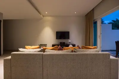 a living room with a couch and a tv at Tropical Serenity - Elegant 1 Bedroom with Pool in Ban Saiyuan (1)