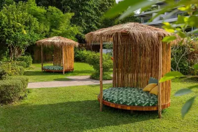 a gazebo with a bed in the grass at Tropical Serenity - Elegant 1 Bedroom with Pool in Ban Saiyuan (1)
