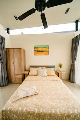 a bedroom with a large bed with a ceiling fan at Townhouse in the very center of Laguna, 600 m from Bang Tao in Phuket