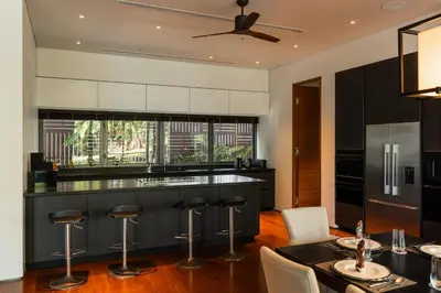 a kitchen with a black island with bar stools at Villa Princess Maria in Kata Beach