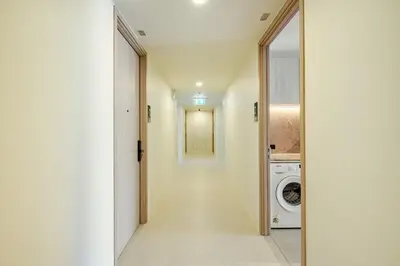 a hallway leading to a laundry room with a washer and dryer at The Ozone Condominium 513 One-Bedroom Apartment in Laguna Phuket