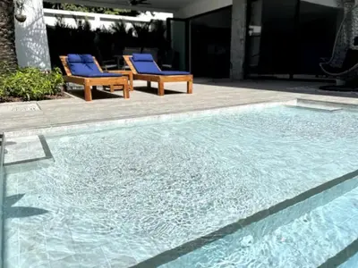 a swimming pool with two blue chairs next to it at Villa Anthoni - Cozy 3 bedrooms with pool in Rawai Beach