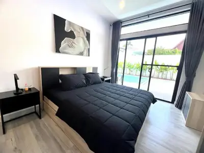 a bedroom with a black bed and a large window at Villa Anthoni - Cozy 3 bedrooms with pool in Rawai Beach