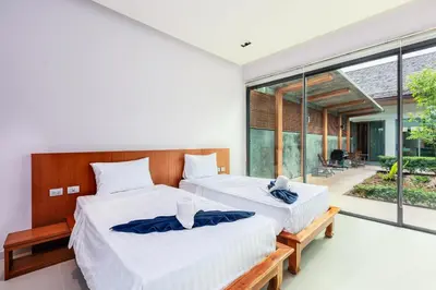 two beds in a bedroom with a large window at Villa Coco - Classy Modern 2 Bedroom Pool Villa in Ban Saiyuan (1)