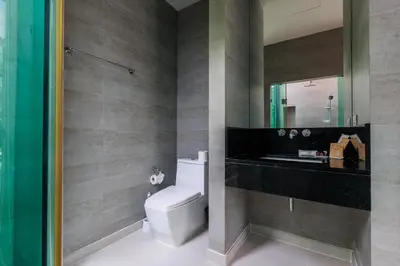 a bathroom with a toilet and a sink and a mirror at Villa Coco - Classy Modern 2 Bedroom Pool Villa in Ban Saiyuan (1)