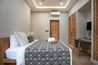 a bedroom with a bed with a teddy bear on it at Villa Chang Thai - Stylish 3 Bedrooms with Private Pool in Rawai Beach