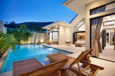a villa with a swimming pool and a house at Villa Chang Thai - Stylish 3 Bedrooms with Private Pool in Rawai Beach