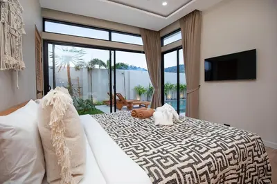 a bedroom with a large bed with a large window at Villa Chang Thai - Stylish 3 Bedrooms with Private Pool in Rawai Beach