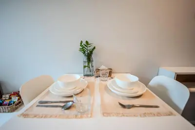 a table with plates and bowls on a table at ZcapeX2 94-17 by SilqStay in Bang Tao Beach