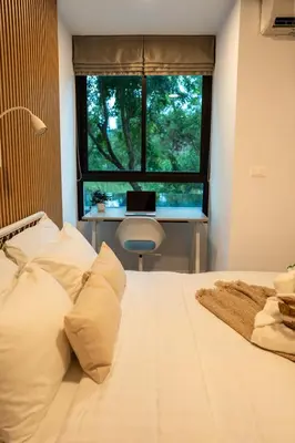 a bedroom with a bed and a window with a laptop at ZcapeX2 94-17 by SilqStay in Bang Tao Beach