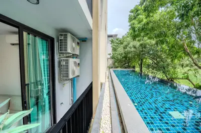a view from the balcony of a house with a swimming pool at ZcapeX2 94-17 by SilqStay in Bang Tao Beach