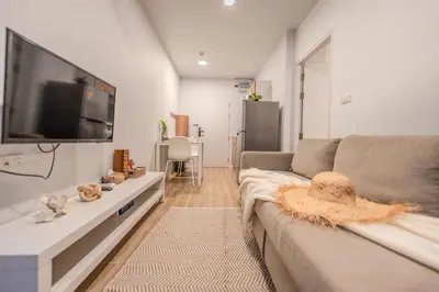 a living room with a couch and a flat screen tv at ZcapeX2 94-17 by SilqStay in Bang Tao Beach