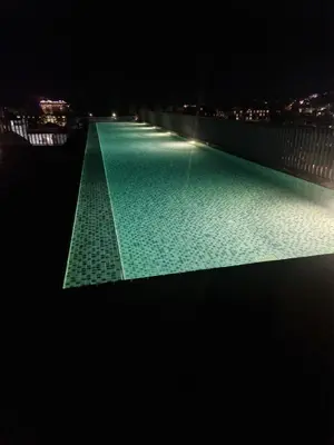 a swimming pool at night with lights on it at The Deck Patong Pool View in Patong Beach