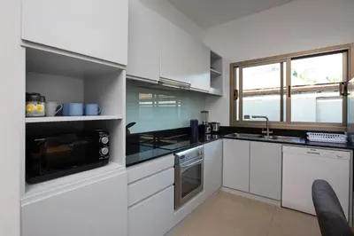 a white kitchen with a sink and a microwave at Villa Dinadi - Superb 2 Bedrooms Pool Villa in Rawai Beach