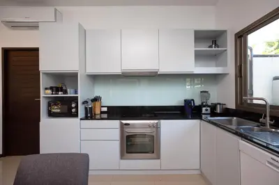 a kitchen with white cabinets and a sink at Villa Dinadi - Superb 2 Bedrooms Pool Villa in Rawai Beach