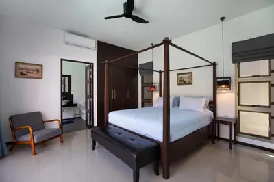 a bedroom with a canopy bed and a chair at Villa Dinadi - Superb 2 Bedrooms Pool Villa in Rawai Beach