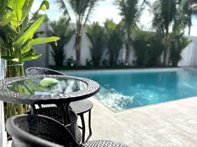 a table and chairs next to a swimming pool at Villa Lola - Modern 3 Bedrooms Villa with Pool in Ban Saiyuan (1)