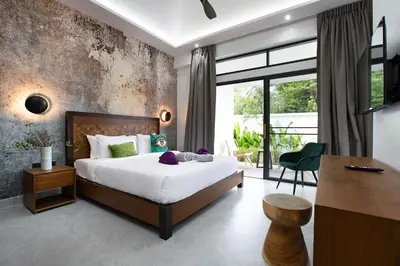 a bedroom with a large bed and a desk and a desk at Villa Matara - Large & Stylish 5 Bedrooms with Pool in Rawai Beach