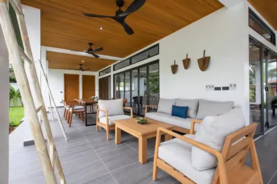 an outdoor patio with a couch and chairs and a table at Villa Matara - Large & Stylish 5 Bedrooms with Pool in Rawai Beach