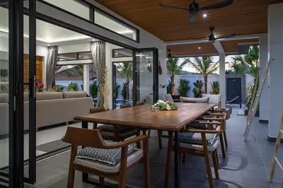 a dining room with a wooden table and chairs at Villa Matara - Large & Stylish 5 Bedrooms with Pool in Rawai Beach