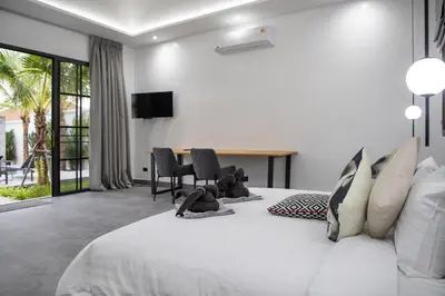 a bedroom with a white bed with a teddy bear on it at Villa Matara - Large & Stylish 5 Bedrooms with Pool in Rawai Beach