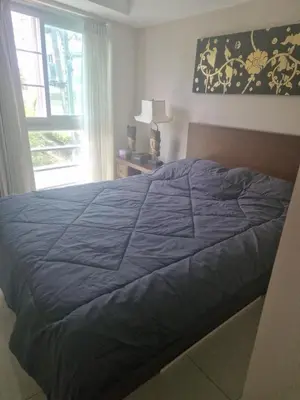 a bedroom with a blue bed with a window at Christian Apartament in Kata Beach