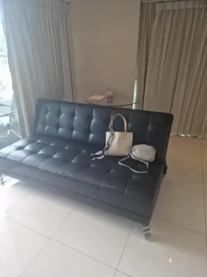 a black leather couch with a purse on it at Christian Apartament in Kata Beach