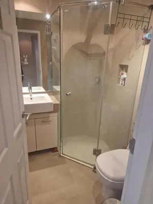 a bathroom with a shower and a toilet and a sink at Christian Apartament in Kata Beach