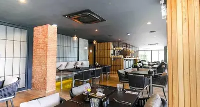 a restaurant with tables and chairs in a room at Diamond Resort Phuket walk to Bangtao Beach in Phuket
