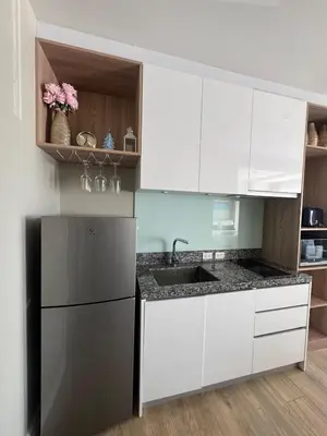a kitchen with white cabinets and a black refrigerator at Diamond Resort Phuket walk to Bangtao Beach in Phuket
