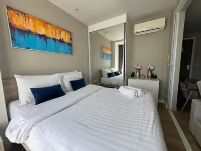 a bedroom with a large white bed with blue pillows at Diamond Resort Phuket walk to Bangtao Beach in Phuket