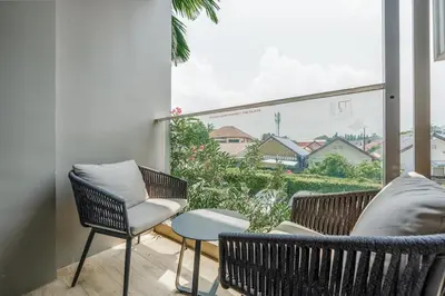 a balcony with chairs and a large window at Diamond Resort Phuket walk to Bangtao Beach in Phuket