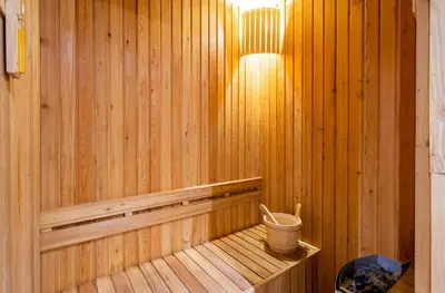 a wooden paneled sauna with a bucket in it at Diamond Resort Phuket walk to Bangtao Beach in Phuket